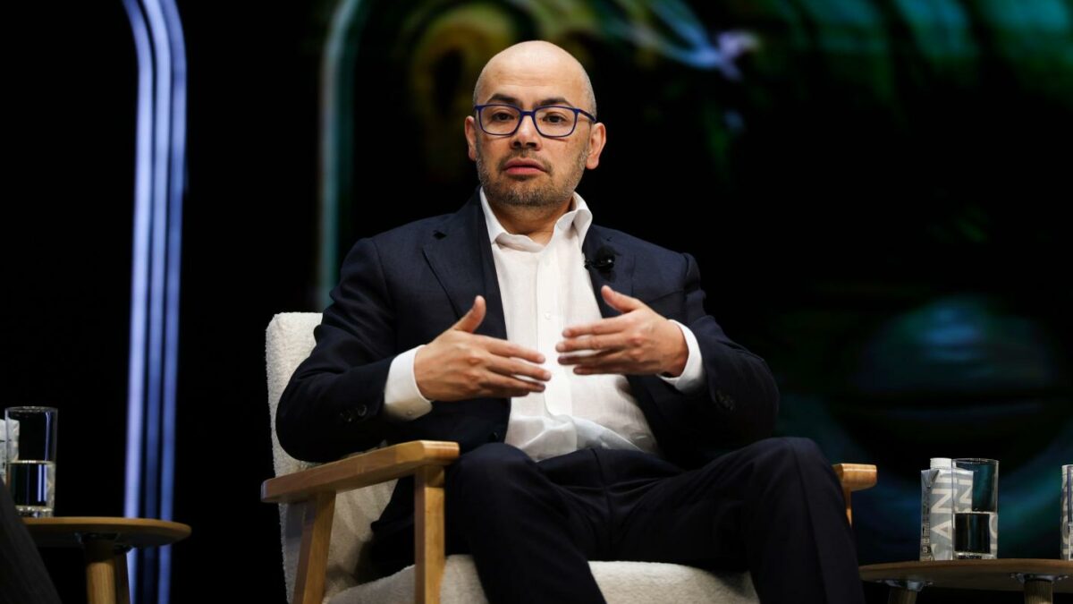 Demis Hassabis sitting in a chair.